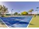 Community tennis court featuring a gated fence, light posts, and mature landscaping at 9717 E Holiday Way, Sun Lakes, AZ 85248