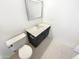 Clean half bathroom featuring a dark vanity with a white countertop, toilet and modern fixtures at 10101 N 91St Ave # 162, Peoria, AZ 85345