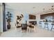 Bright dining room with a round table, stylish chairs and an adjacent kitchen with stainless steel appliances and bar seating at 10152 E Ursula Ave, Mesa, AZ 85212