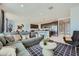 Spacious living room with a grey sectional and an adjacent kitchen featuring stainless steel appliances and bar seating at 10152 E Ursula Ave, Mesa, AZ 85212