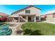 Lush backyard with a private pool, covered patio, green lawn, and beautiful landscaping at 11317 W Cottonwood Ln, Avondale, AZ 85392