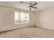 Bedroom with a ceiling fan and a large window overlooking the neighborhood at 11317 W Cottonwood Ln, Avondale, AZ 85392