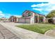 Inviting two-story home with lush front lawn, driveway, and desert landscaping at 11317 W Cottonwood Ln, Avondale, AZ 85392