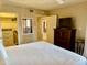 Bright bedroom with a walk-in closet, a white comforter on the bed, and a wooden dresser with a television at 12222 N Paradise Village Pkwy # 321, Phoenix, AZ 85032