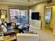 Comfortable living room with a balcony, a TV, and views leading into a bedroom at 12222 N Paradise Village Pkwy # 321, Phoenix, AZ 85032