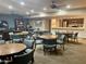 A well lit recreation room features seating at tables and a servery with kitchen in background at 12222 N Paradise Village Pkwy # 321, Phoenix, AZ 85032