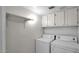 Bright laundry room with included washer and dryer and additional cabinet storage at 13811 N 42Nd Pl, Phoenix, AZ 85032