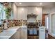 Bright kitchen boasts stainless steel appliances, white cabinetry, and stylish patterned backsplash at 1402 E Granada Rd, Phoenix, AZ 85006