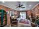 The living room with brick walls features a ceiling fan, comfortable seating, and a cozy rug at 1402 E Granada Rd, Phoenix, AZ 85006