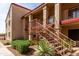 Stylish condo building featuring stair access, desert plants, and a red tile roof at 1440 N Idaho Rd # 2053, Apache Junction, AZ 85119