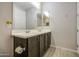 This bathroom features double sinks, a large mirror, and modern fixtures at 14413 W Dahlia Dr, Surprise, AZ 85379