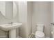 This powder room features a pedestal sink and toilet at 14413 W Dahlia Dr, Surprise, AZ 85379