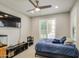 This bright bedroom includes a ceiling fan, a window with shutters, and a black entertainment center at 14413 W Dahlia Dr, Surprise, AZ 85379