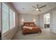 Bedroom with a ceiling fan, bedside sconces, and natural light from the window at 14413 W Dahlia Dr, Surprise, AZ 85379