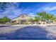 Charming exterior view of building, featuring wood accents, well-maintained landscaping, and ample parking at 14413 W Dahlia Dr, Surprise, AZ 85379