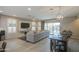 Bright and airy living room with a large sectional, stylish lighting, and access to the backyard at 14413 W Dahlia Dr, Surprise, AZ 85379