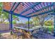 Stylish outdoor bar area under a pergola, perfect for entertaining guests with ample seating and a scenic view at 14413 W Dahlia Dr, Surprise, AZ 85379