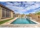 Backyard pool featuring travertine deck, waterfall feature, artificial turf, and a playset for  at 14413 W Dahlia Dr, Surprise, AZ 85379