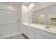 Bright bathroom featuring a double sink vanity and walk-in shower with subway tile surround at 15585 W Williams St, Goodyear, AZ 85338