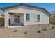 Home exterior showcasing a covered patio and a low-maintenance desert landscape at 15585 W Williams St, Goodyear, AZ 85338