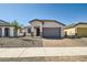Charming single-story home with a brick driveway, neutral stucco, and a well-manicured desert landscape at 15585 W Williams St, Goodyear, AZ 85338