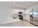 Well-lit kitchen with stainless steel appliances, white cabinetry, and a quartz countertop island at 15585 W Williams St, Goodyear, AZ 85338