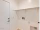 Bright laundry room with shelving and hookups at 15585 W Williams St, Goodyear, AZ 85338