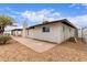 Backyard view of the home showing the patio, desert landscaping, and exterior paint colors at 1649 W Carmel Ave, Mesa, AZ 85202