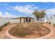 Backyard with a circular red brick border, desert landscaping, and a shaded pergola at 1649 W Carmel Ave, Mesa, AZ 85202