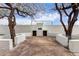 A unique backyard with a custom-built outdoor fireplace and seating area, framed by mature trees at 1649 W Carmel Ave, Mesa, AZ 85202