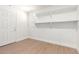 Bright, white basement room with shelving and wood-look flooring at 1649 W Carmel Ave, Mesa, AZ 85202