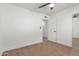 This bedroom showcases wood floors, white walls and trim, a ceiling fan, and a sliding door closet at 1649 W Carmel Ave, Mesa, AZ 85202