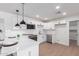 Modern white kitchen features a quartz countertop, stainless steel appliances, and a breakfast bar at 1649 W Carmel Ave, Mesa, AZ 85202