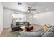 Comfortable living area with ample seating, wood floors, and natural light from the large front window at 1649 W Carmel Ave, Mesa, AZ 85202