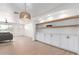 Bright living room features custom built-ins, hardwood floors, and stylish lighting fixture at 1649 W Carmel Ave, Mesa, AZ 85202
