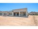 The exterior back of the home features a covered patio and desert landscaping at 18716 N 269Th Ln, Buckeye, AZ 85396