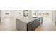 A kitchen island with a sink, dark wood cabinets, stainless steel appliances, and wood-style flooring at 18716 N 269Th Ln, Buckeye, AZ 85396