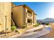 Exterior of a tan two-story condo building with private balconies and a walkway at 1880 E Morten Ave # 242, Phoenix, AZ 85020