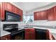 Efficient kitchen with black appliances, cherry wood cabinets and a window at 1880 E Morten Ave # 242, Phoenix, AZ 85020