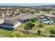 Charming home with a sparkling pool, covered lounge area, lush green lawns, and convenient garage access in a desert setting at 19535 E Via De Olivos Rd, Queen Creek, AZ 85142