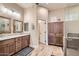 A well-appointed bathroom featuring dual sinks, marble countertops, and a glass-enclosed shower at 19535 E Via De Olivos Rd, Queen Creek, AZ 85142