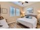 Comfortable bedroom boasts light-colored walls, wood-look floors, and shuttered windows at 19535 E Via De Olivos Rd, Queen Creek, AZ 85142