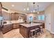 Spacious kitchen with wood cabinets, marble island, stainless steel appliances, and three modern pendant lights at 19535 E Via De Olivos Rd, Queen Creek, AZ 85142