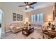 A stylish living room featuring a comfortable sofa, two shuttered windows, and decorative wall art at 19535 E Via De Olivos Rd, Queen Creek, AZ 85142
