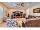 Spacious living room with a large entertainment center, ceiling fan, and comfortable seating at 19535 E Via De Olivos Rd, Queen Creek, AZ 85142