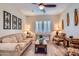 Cozy living room featuring two shuttered windows, a ceiling fan, comfortable sofa, and decor at 19535 E Via De Olivos Rd, Queen Creek, AZ 85142