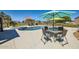 Inviting backyard with a sparkling pool, spa, and dining area, ideal for outdoor gatherings and leisure at 19535 E Via De Olivos Rd, Queen Creek, AZ 85142