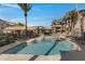 Resort-style swimming pool with lounge seating, umbrellas, and a covered outdoor grilling area at 2025 E Campbell Ave # 114, Phoenix, AZ 85016