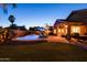 Backyard pool area illuminated at dusk, complimented by professional landscaping, and an outdoor seating area at 203 W Raven Dr, Chandler, AZ 85286