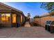 Paver patio at twilight features an outdoor grill, dining area, and heater, all enclosed by a block wall at 203 W Raven Dr, Chandler, AZ 85286